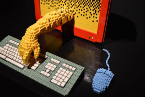 A lego hand typing on a lego keyboard