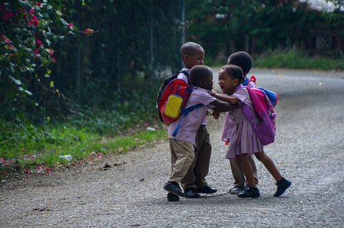 Four young children play fight in the street